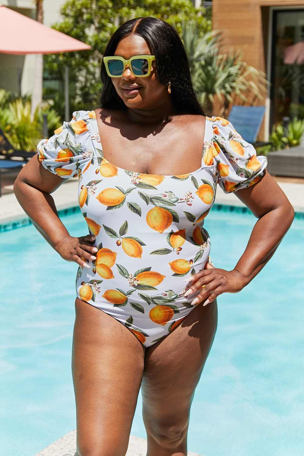 Marina West citrus orange puff sleeve one-piece swimsuit by poolside.