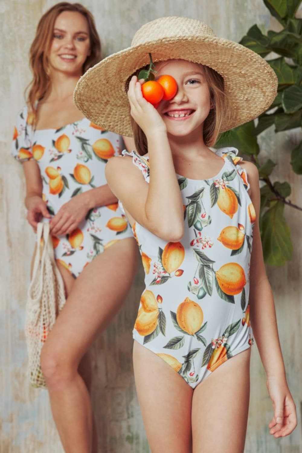 Citrus orange puff sleeve one-piece swimsuit with fruit print.