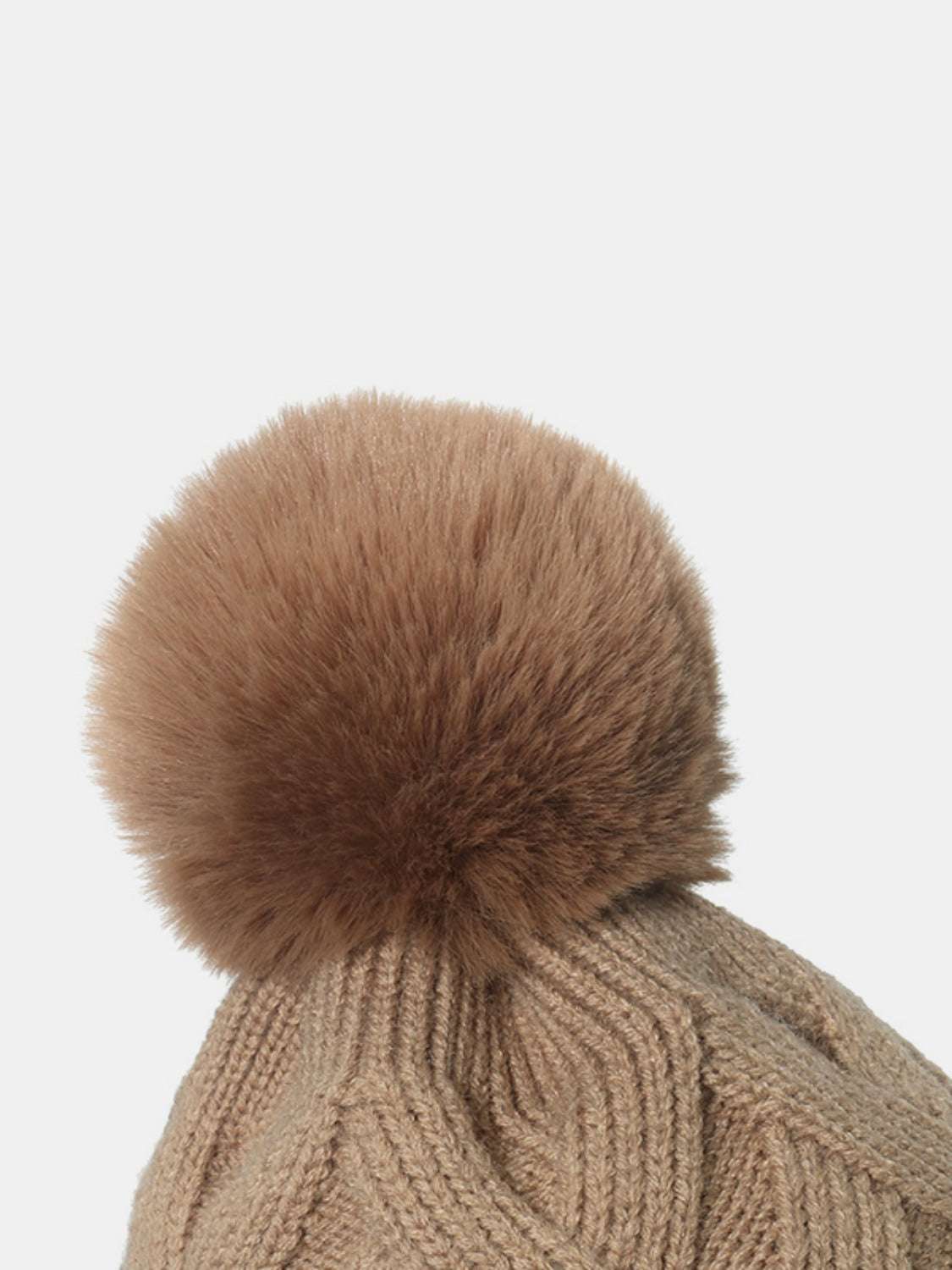 Beige roll rim hat with pompom made of acrylic and polyester.