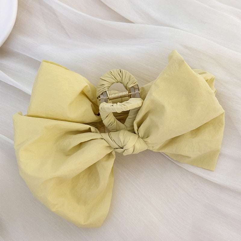 Bow hair claw clip made of polyester fabric.