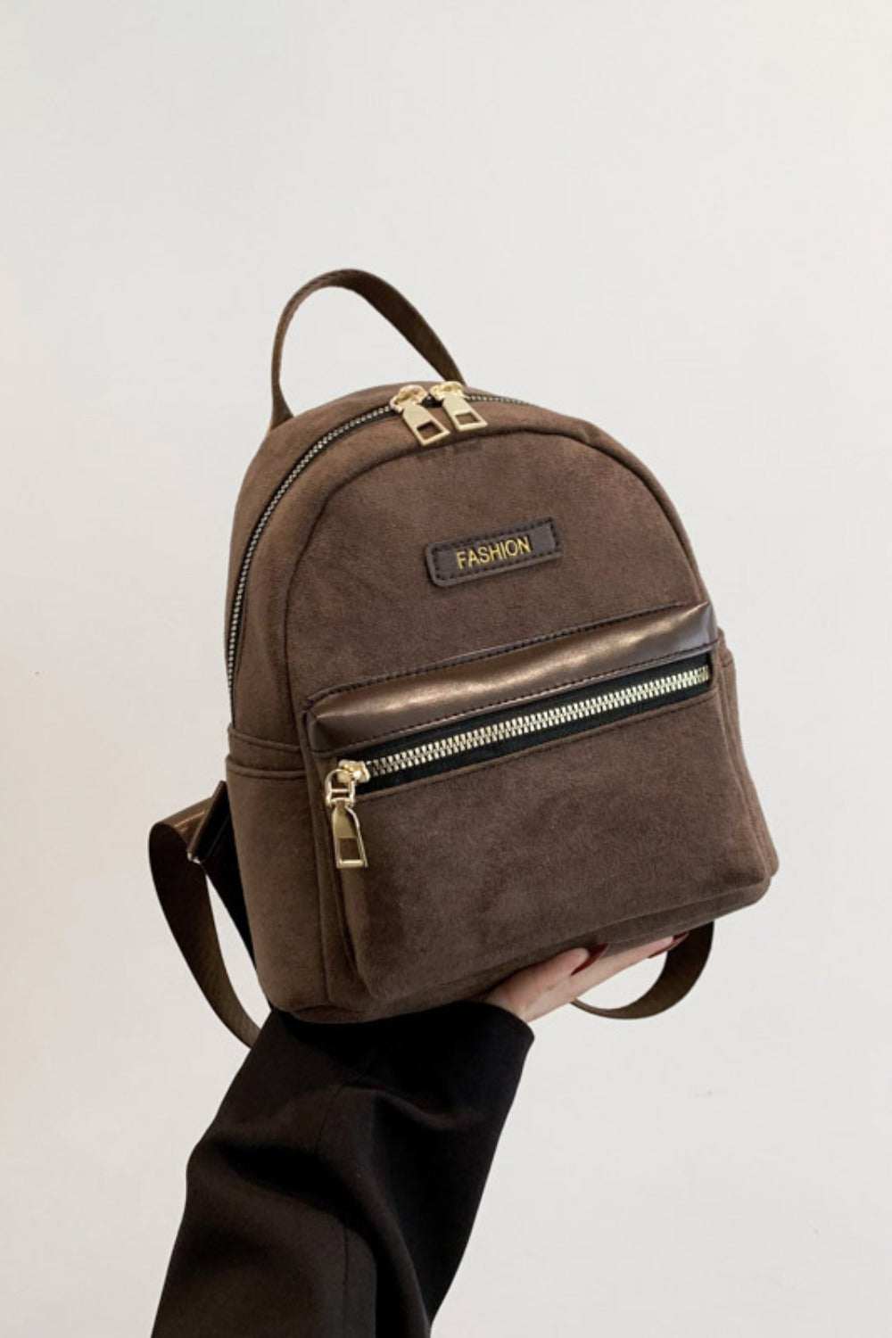 Small suede adjustable strap backpack bag with front zipper pocket.