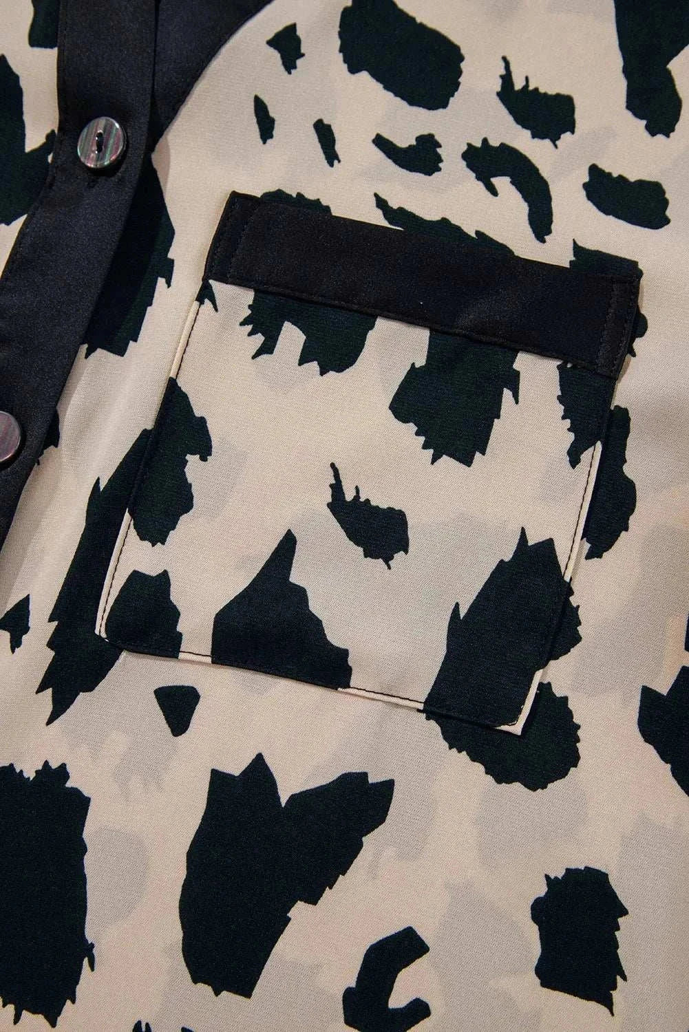 Close-up of a buttoned, opaque long sleeve top made from 100% polyester with a stylish pattern.