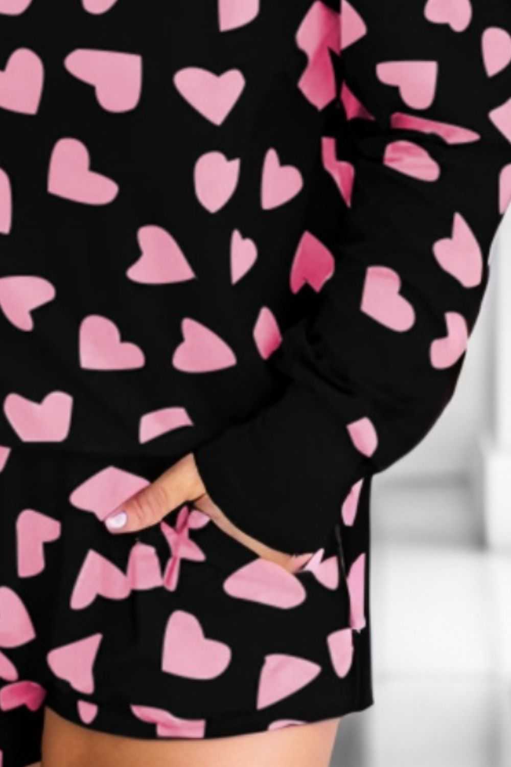 Heart print round neck top and shorts lounge set with pink hearts on black fabric.