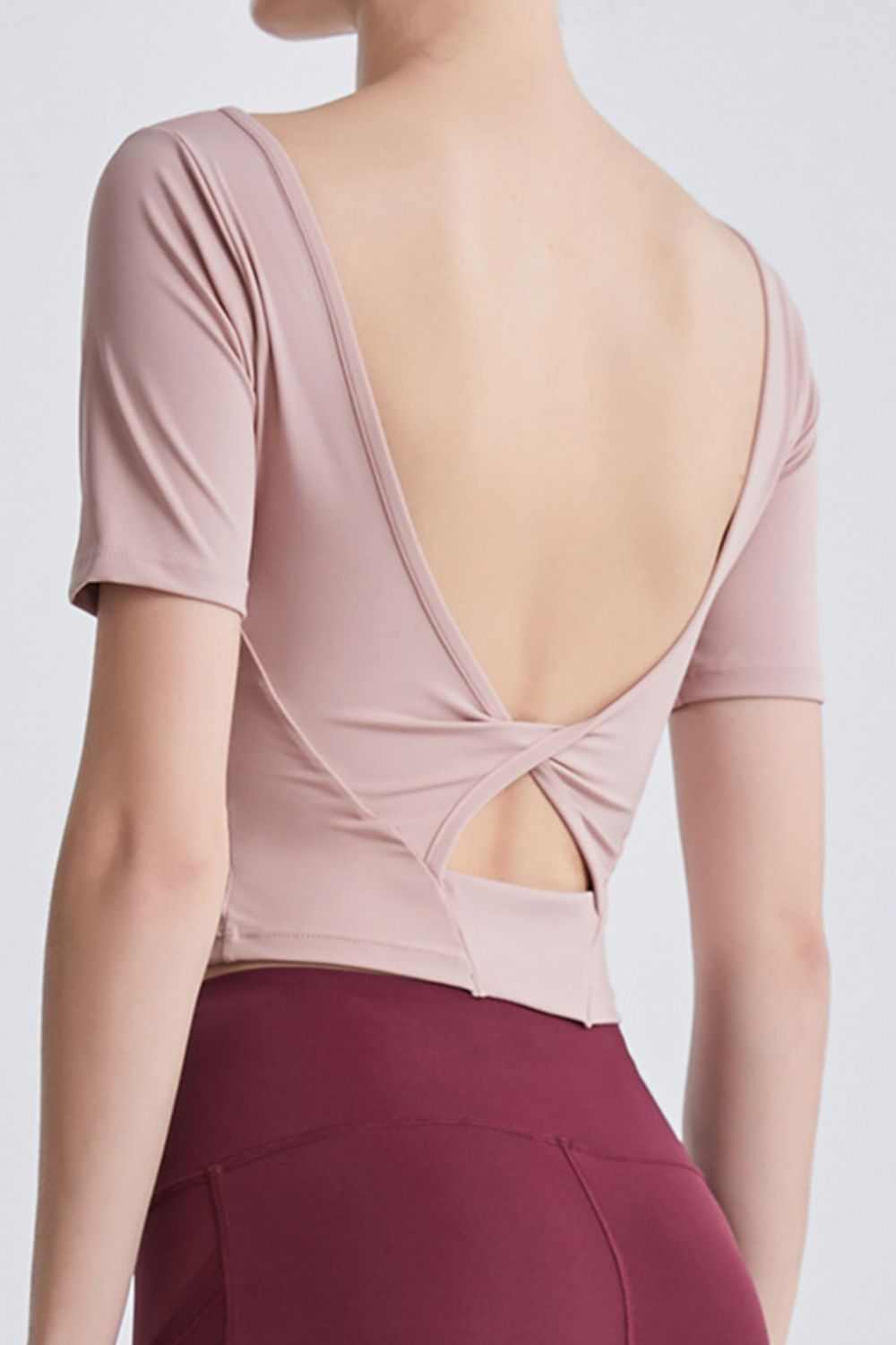 Cutout Backless Round Neck Active T-Shirt with stretch fabric and opaque material.