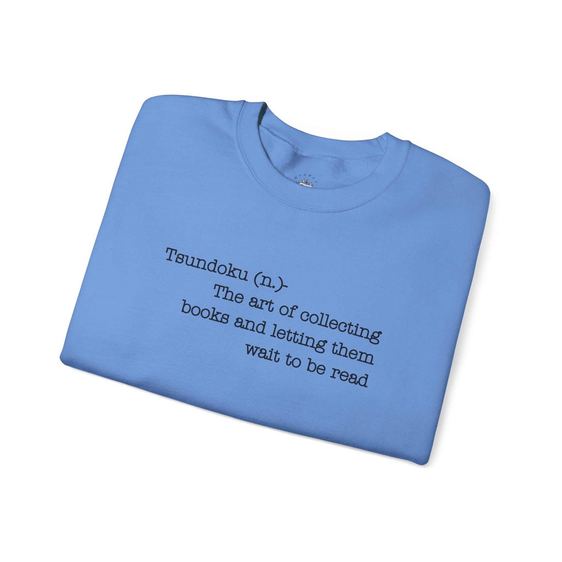 Tsundoku crewneck sweatshirt folded, displaying definition text and vibrant blue fabric.