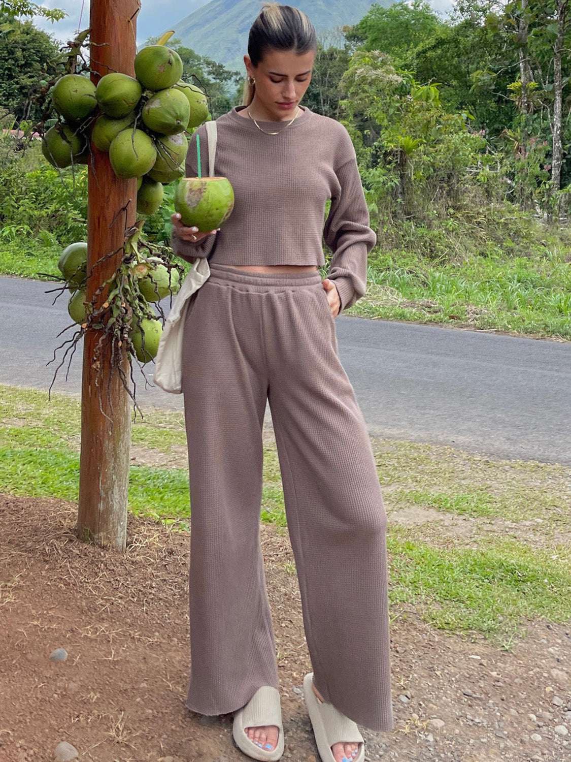 Waffle-knit round neck top and pants set in a natural outdoor setting.