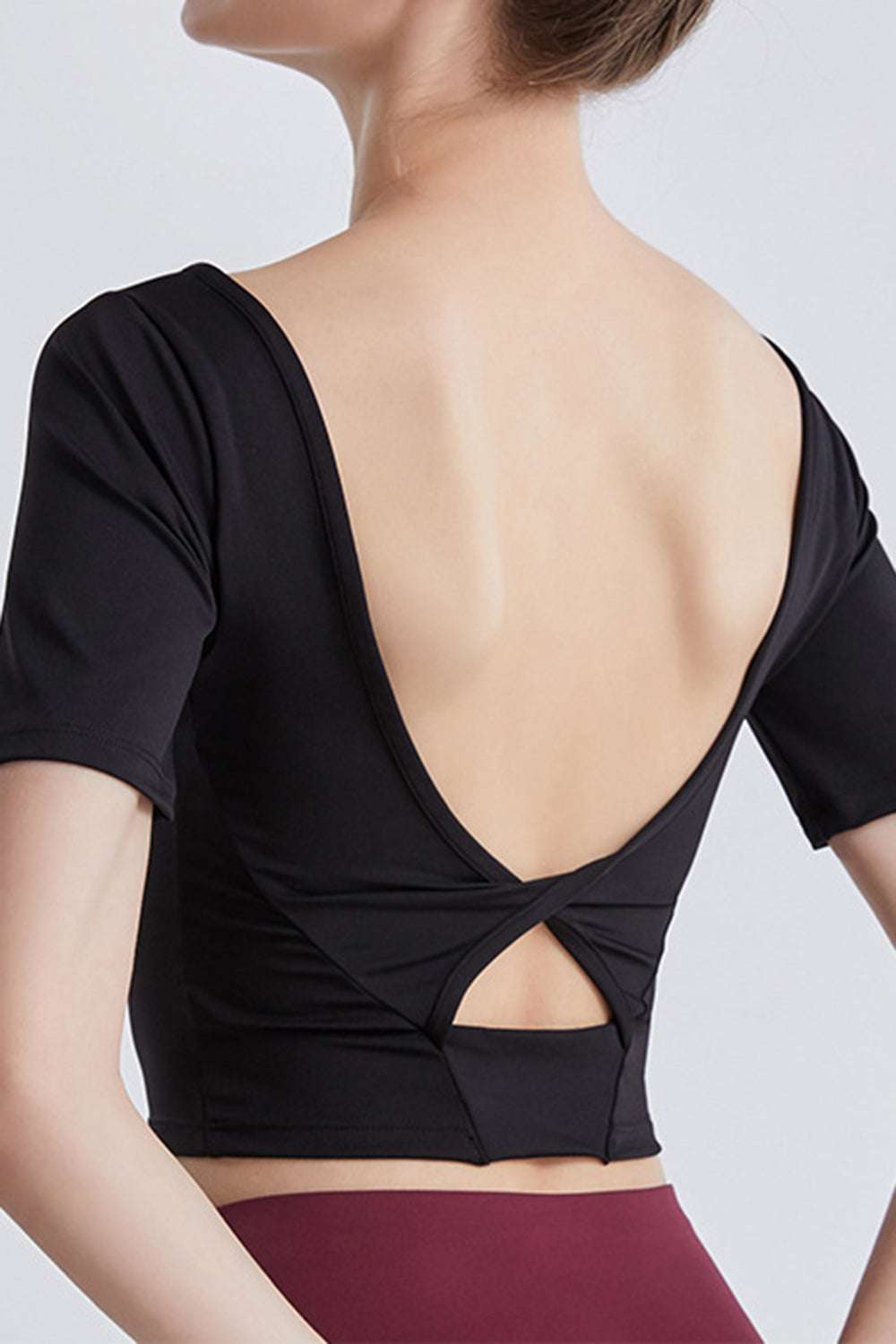 Cutout backless round neck active T-shirt in black, highly stretchy fabric, perfect for workouts.