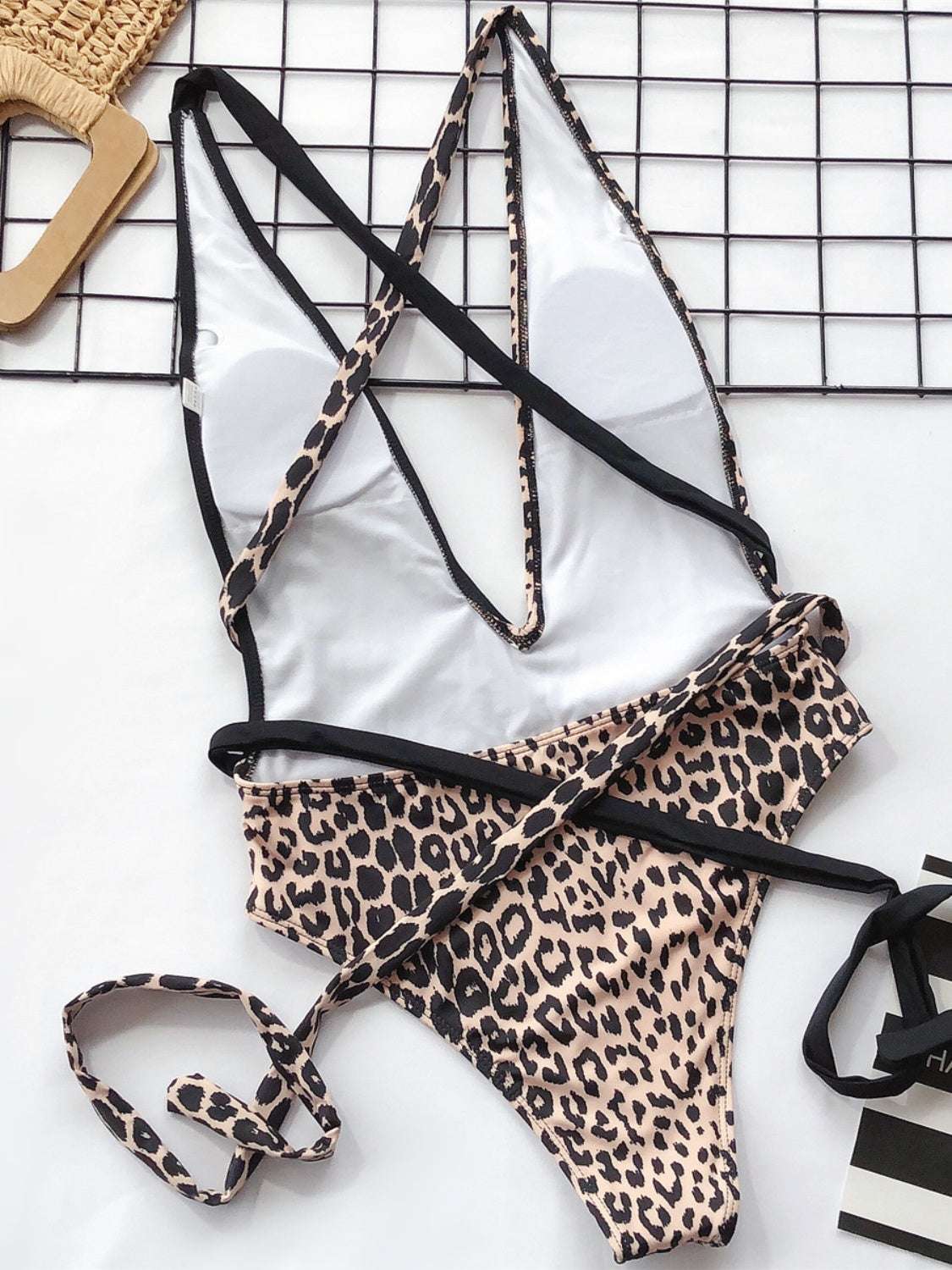 Tied leopard plunge one-piece swimwear with removable padding, no underwire, and stretchy fabric.