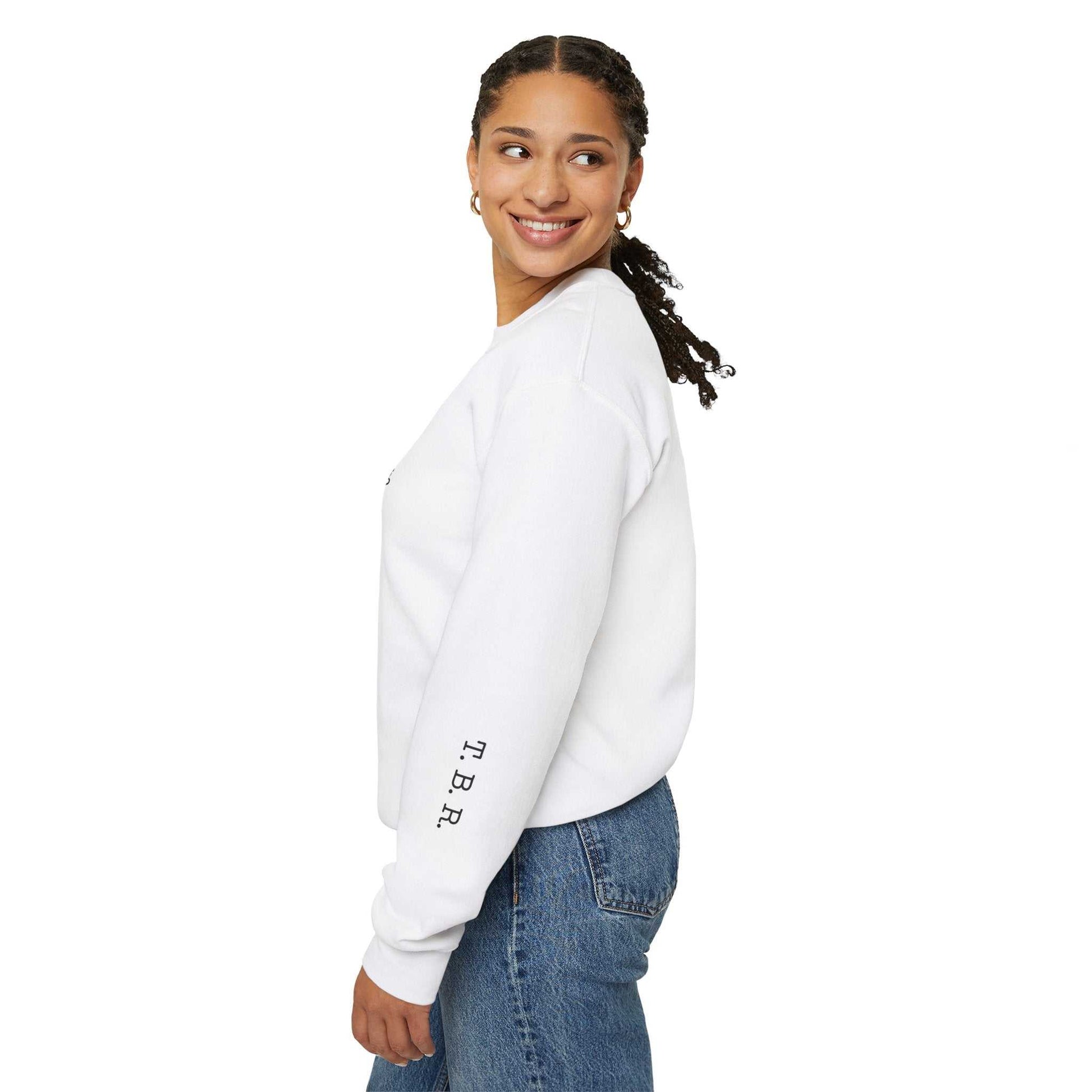 Tsundoku Crewneck Sweatshirt with T.B.R. on sleeve, worn by woman facing sideways.