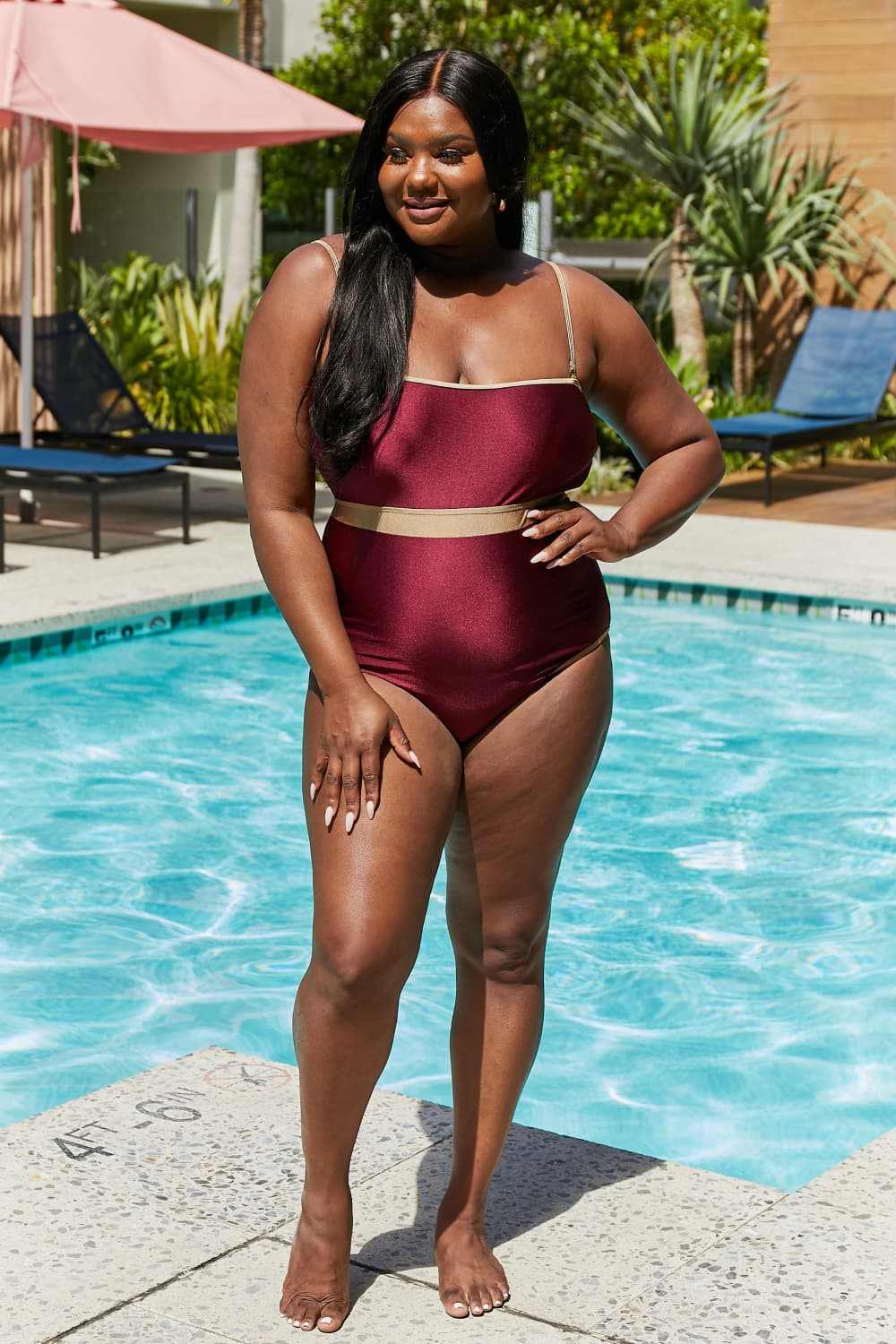 Marina West Swim Wave Break Contrast Trim One-Piece swimsuit in wine by poolside.