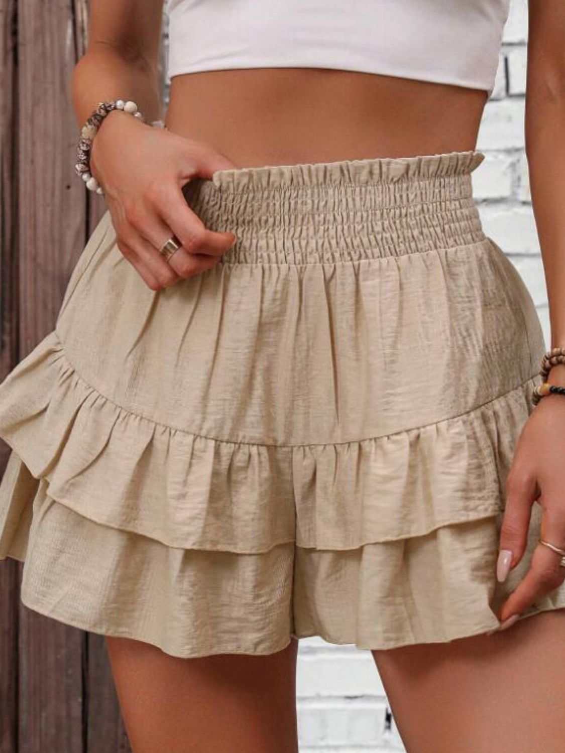 Smocked layered shorts with ruffled details in beige color.