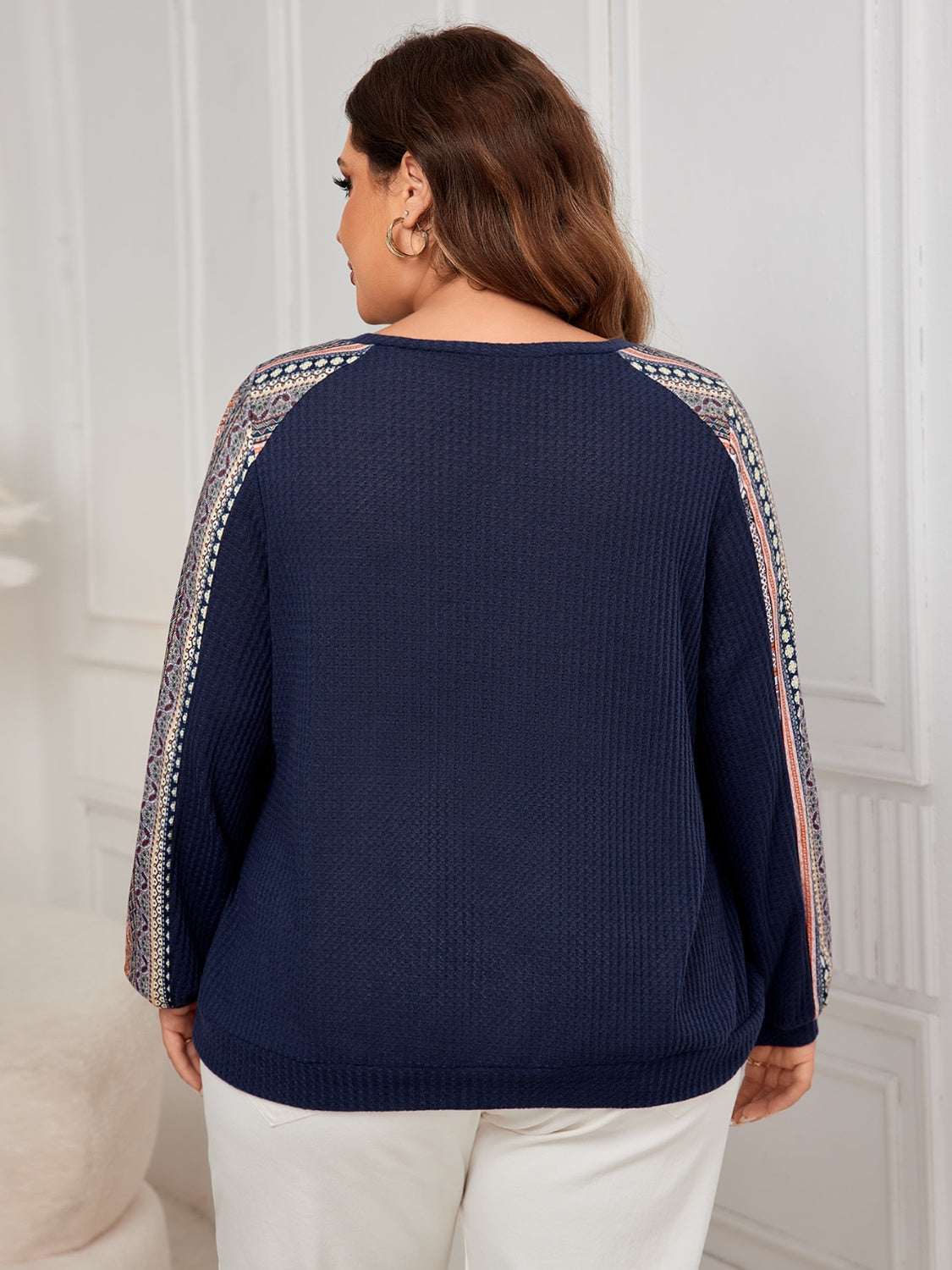 Plus size printed long sleeve navy sweatshirt with pattern details on sleeves.