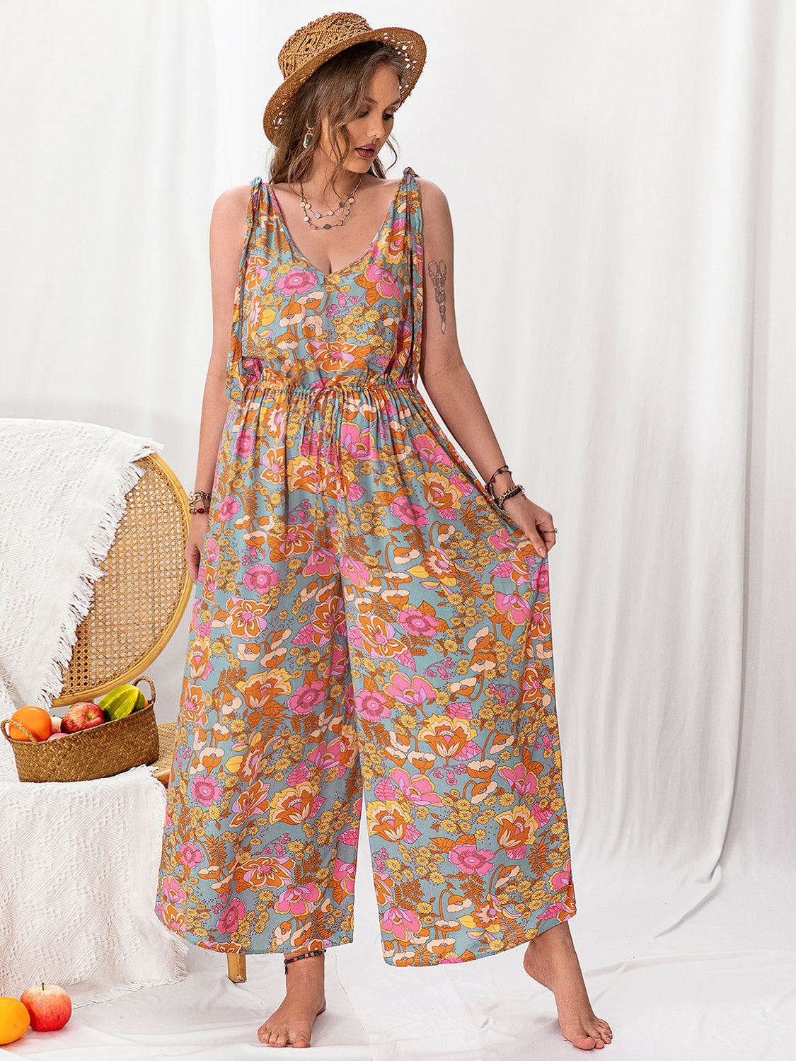 Plus size printed wide leg sleeveless jumpsuit with tied and backless features.