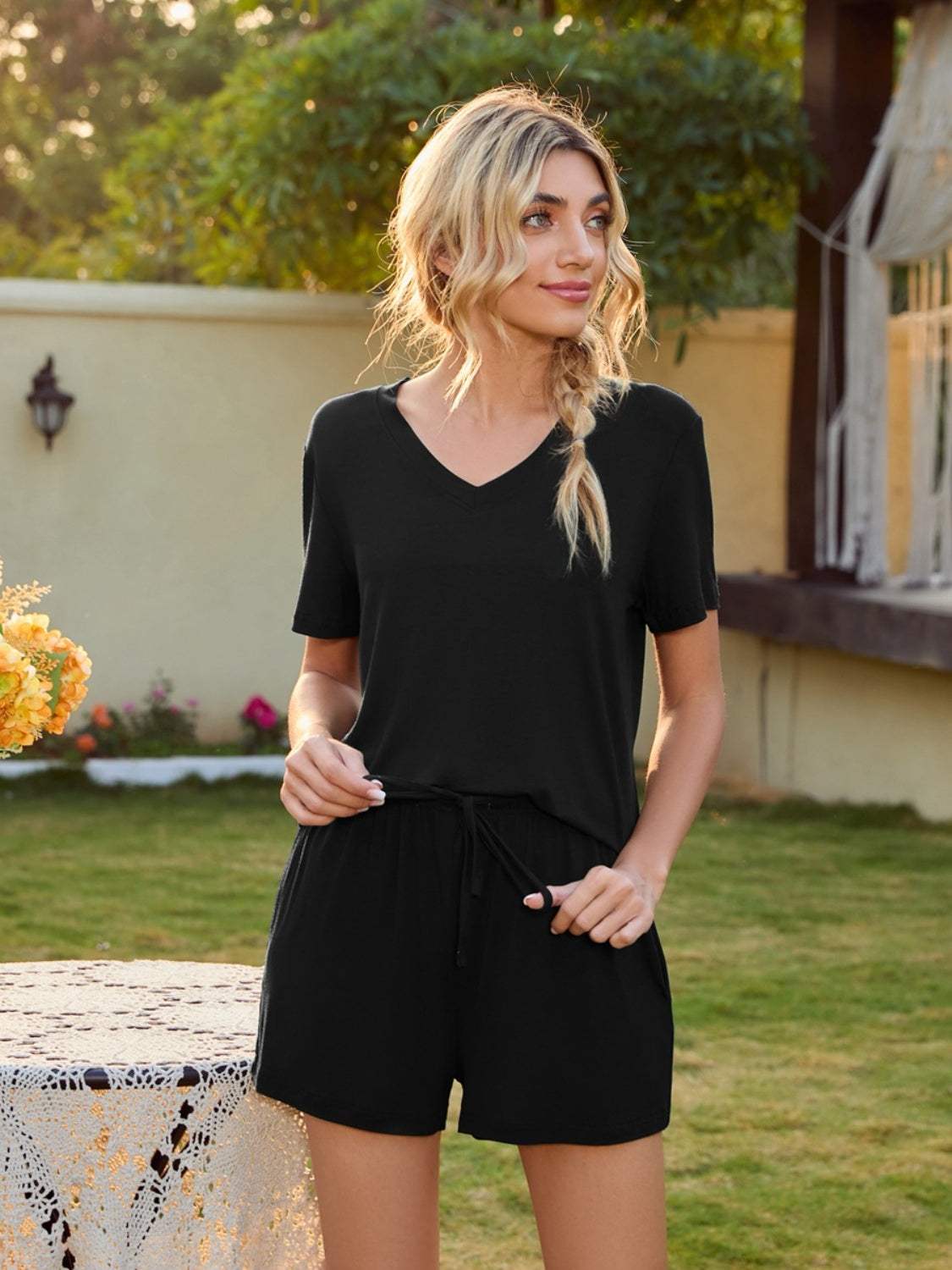 V-Neck Short Sleeve Top and Pocketed Shorts Lounge Set in black, casual style, outdoor setting.