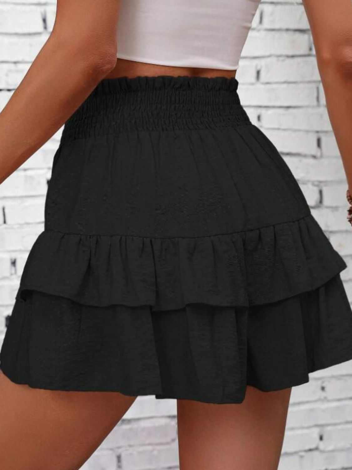 Black smocked layered shorts with ruffled design, 100% polyester.