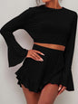 Round neck long sleeve top and ruffled shorts set in black with peplum detail.