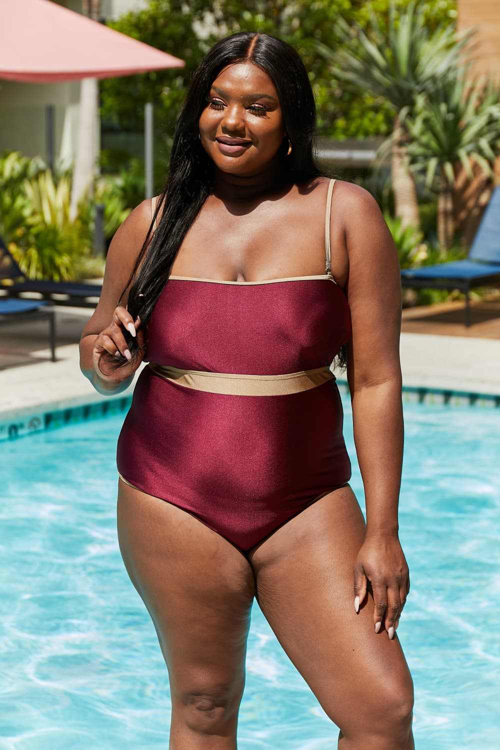 Marina West Swim Wave Break Contrast Trim One-Piece in Wine by the pool, featuring contrast waistband and open-back detail.