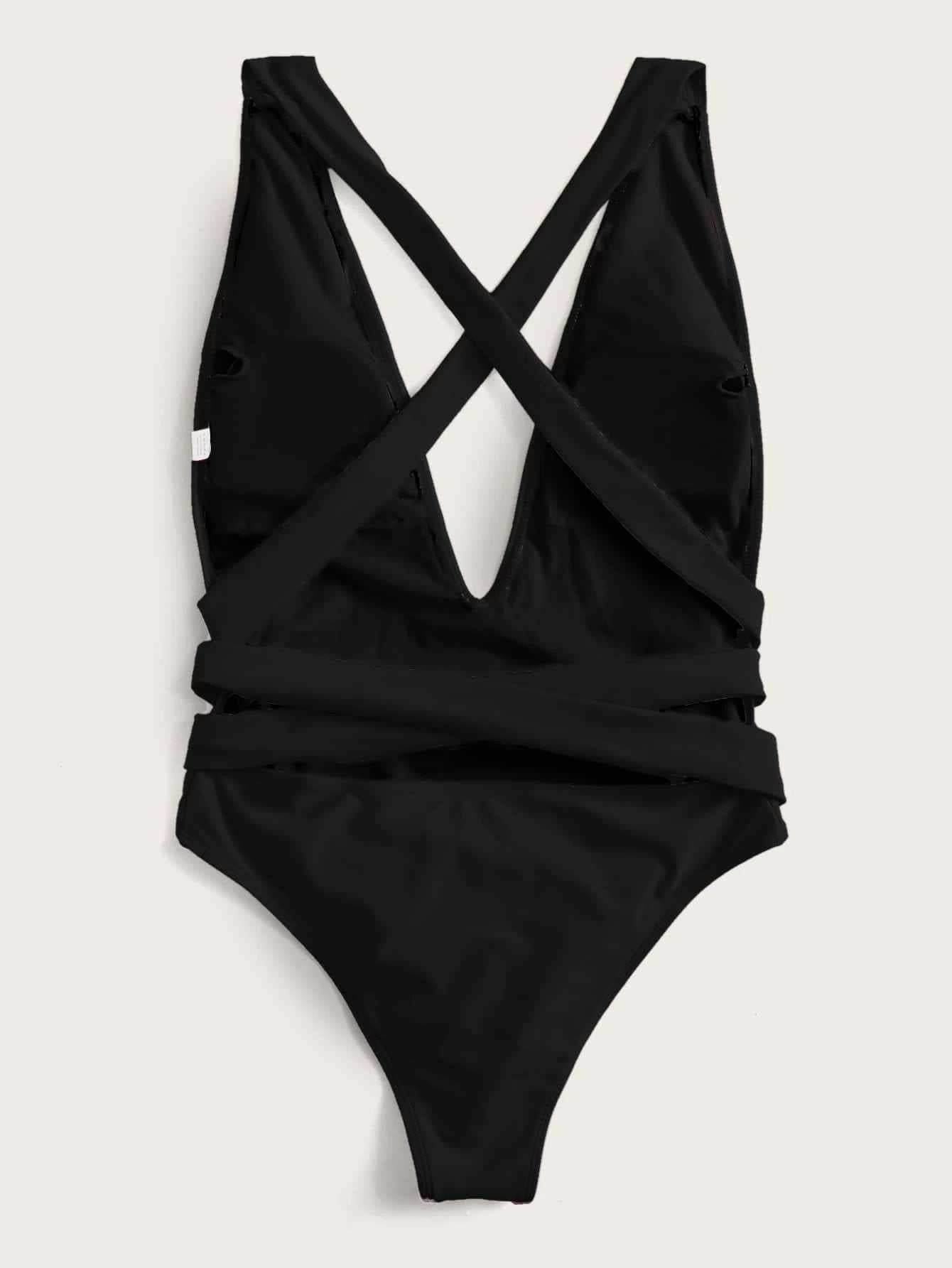 Halter neck deep V tied one-piece swimsuit with crisscross straps and snakeskin pattern.