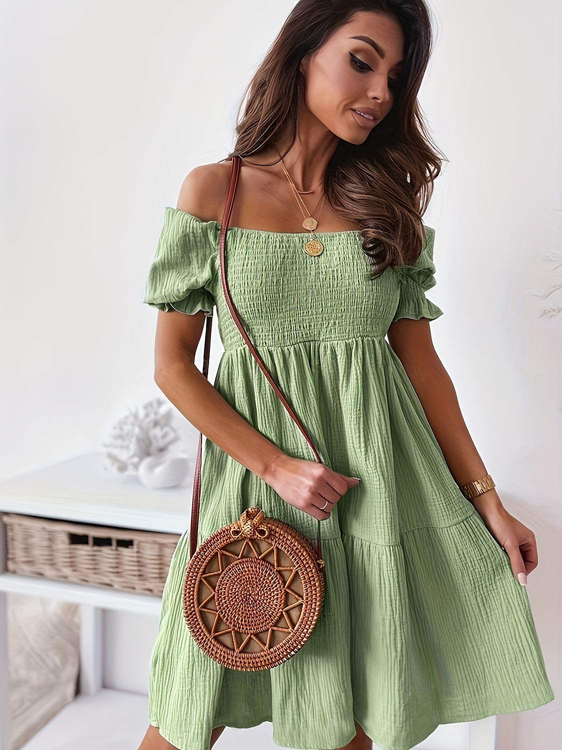 Woman wearing a green full-size ruffled off-shoulder short sleeve dress with a ruched detail.