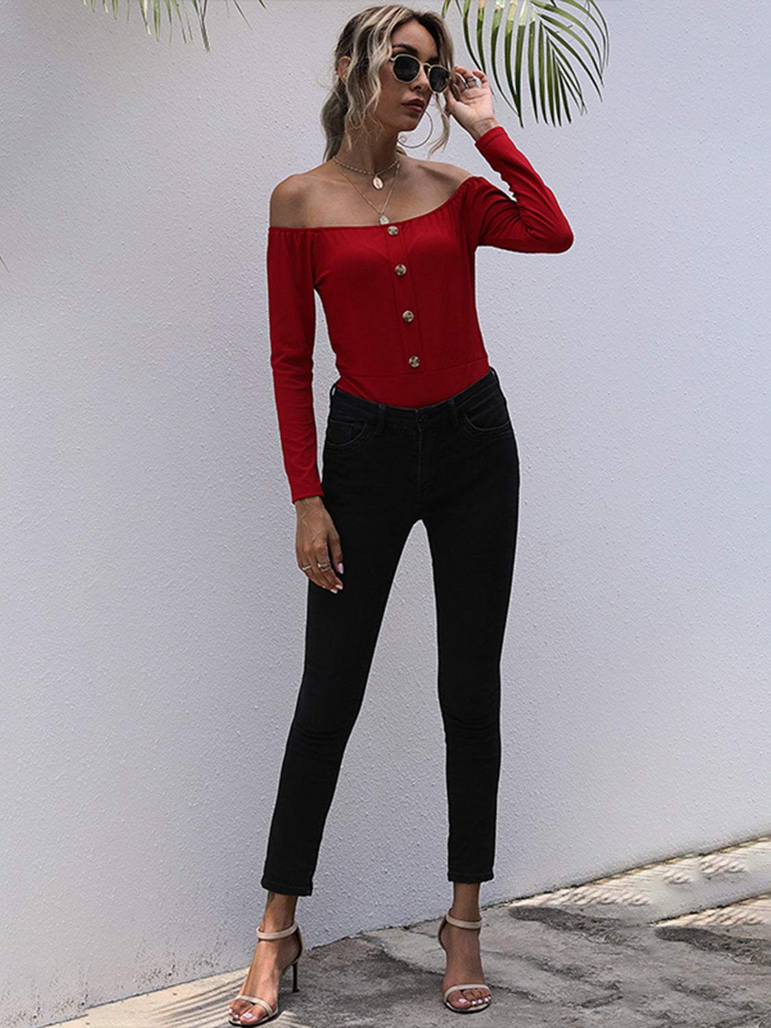 Off-shoulder long sleeve bodysuit with decorative buttons and moderate stretch.