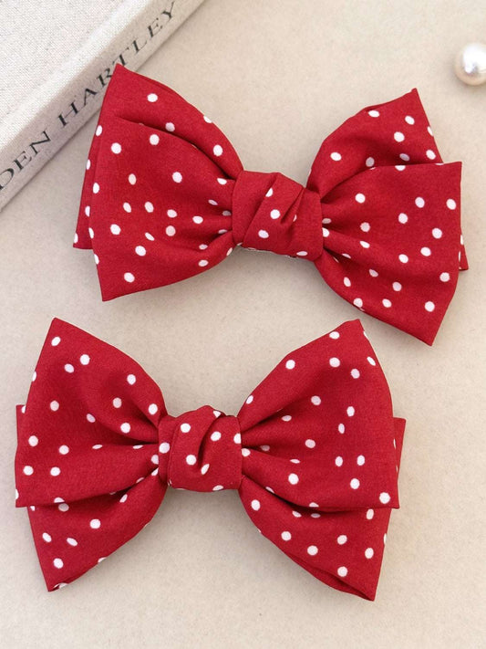 Red 2-piece polka dot bow hair clip set made of polyester.