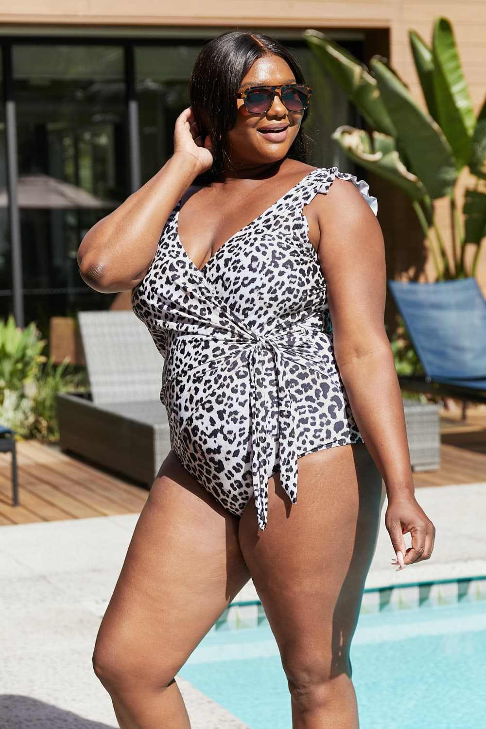 Marina West Swim full-size float on ruffle faux wrap one-piece leopard swimsuit with surplice neckline.