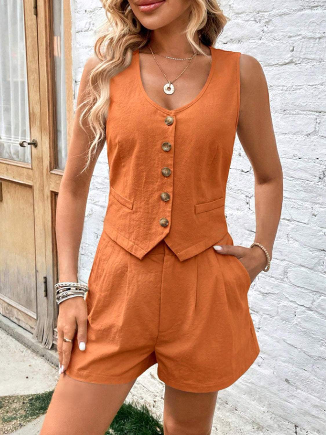 Scoop neck sleeveless top and shorts set in orange, buttoned with pockets, made of 100% cotton.