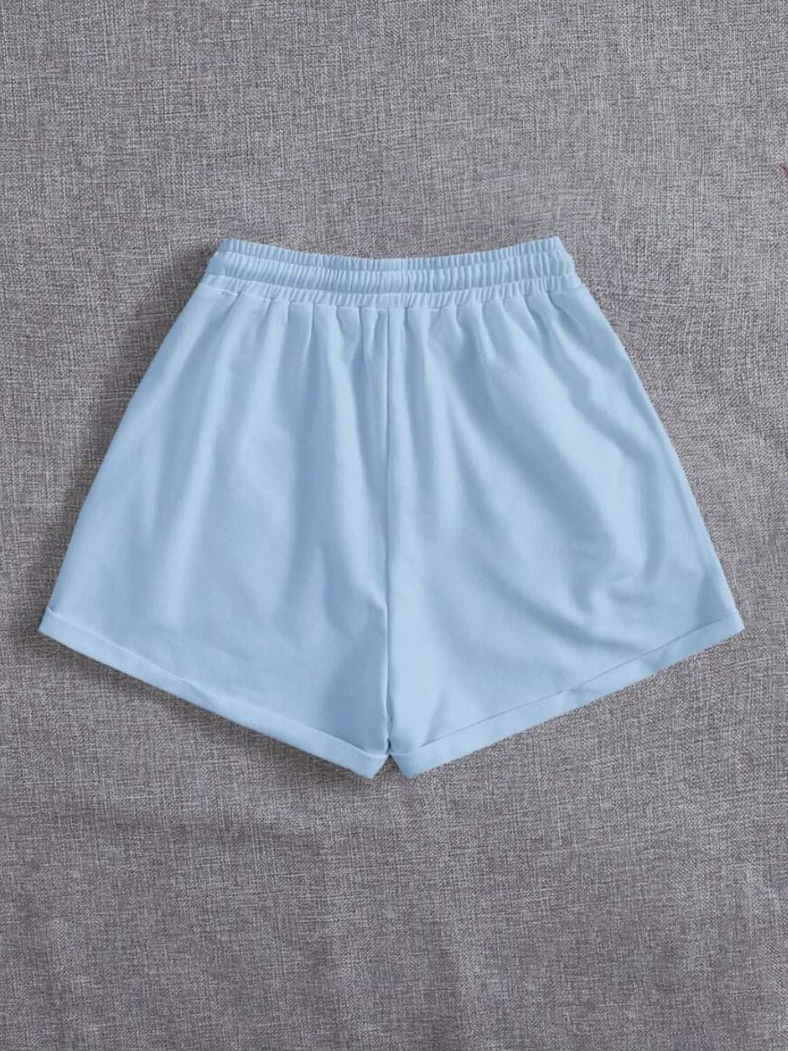 Light blue drawstring pocketed elastic waist shorts made of 100% polyester.