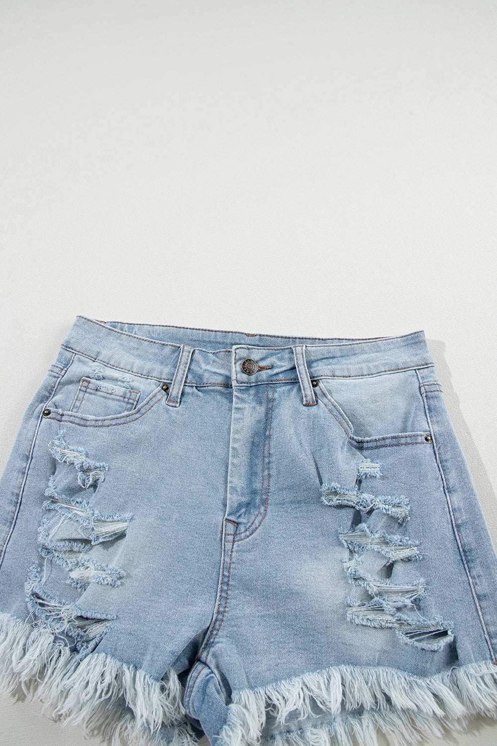 Distressed raw hem denim shorts with slight stretch and frayed edges.