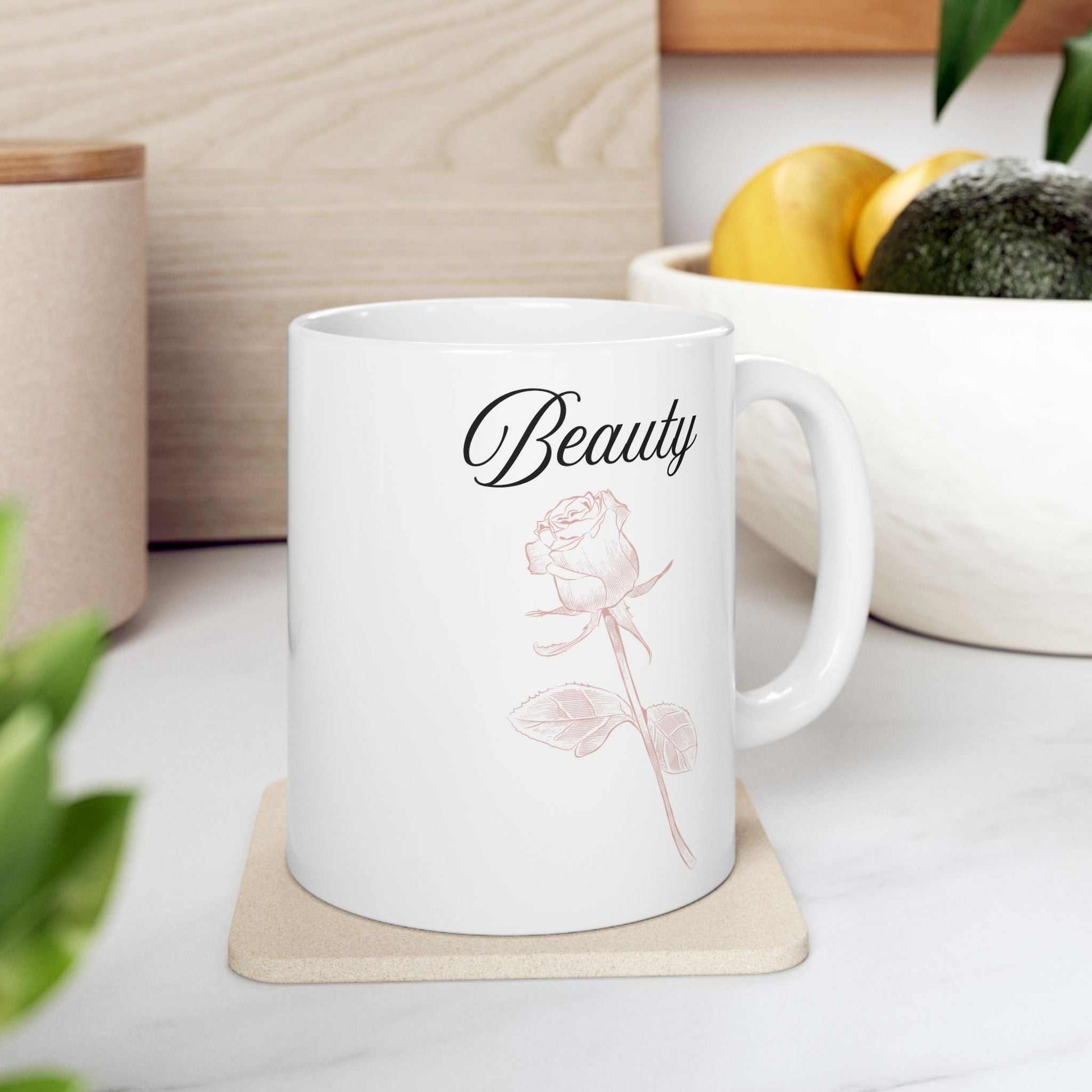 Ceramic mug with "Beauty" text and dusty rose design.