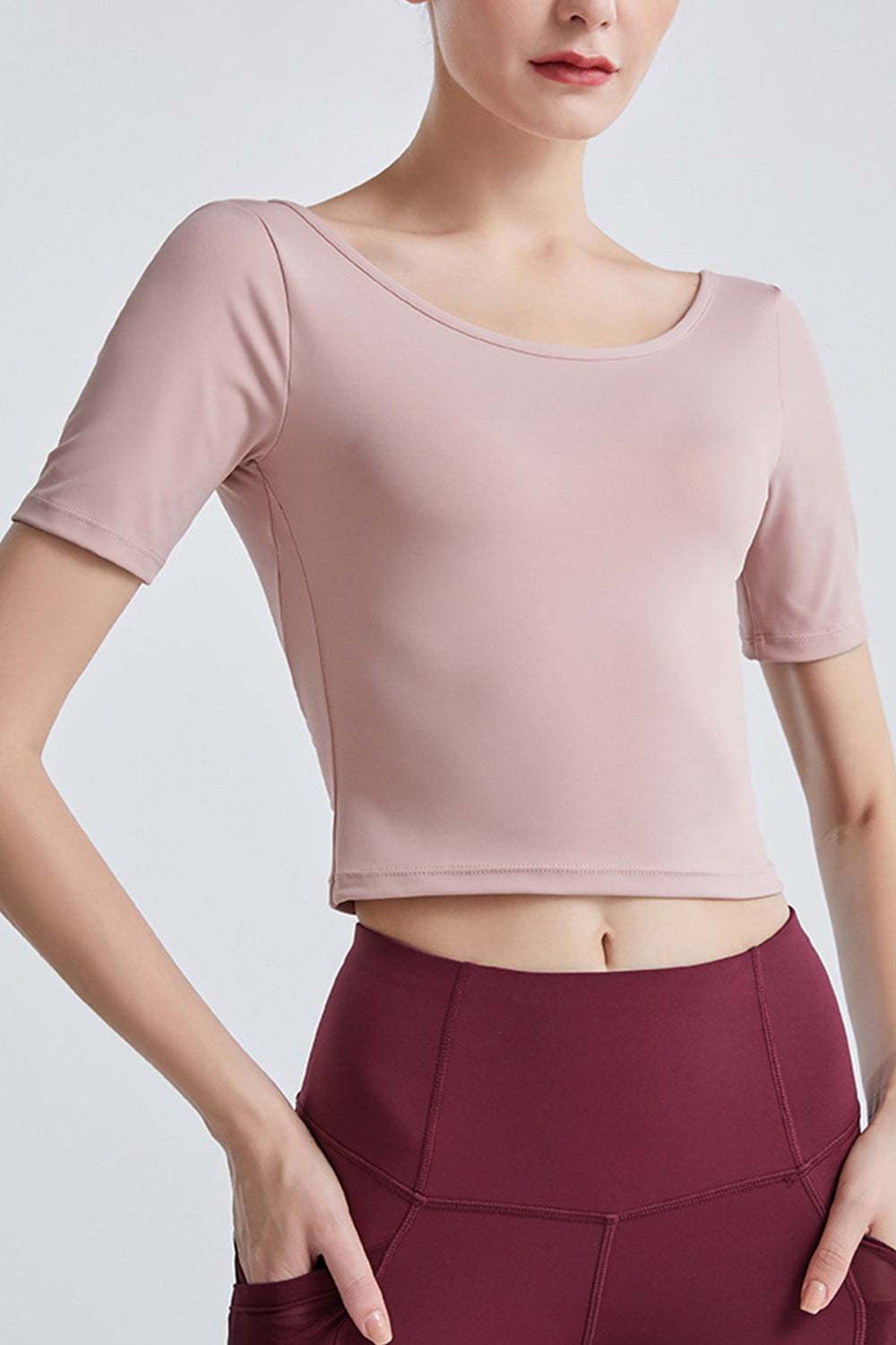 Cutout backless round neck active t-shirt in light pink, highly stretchy fabric.