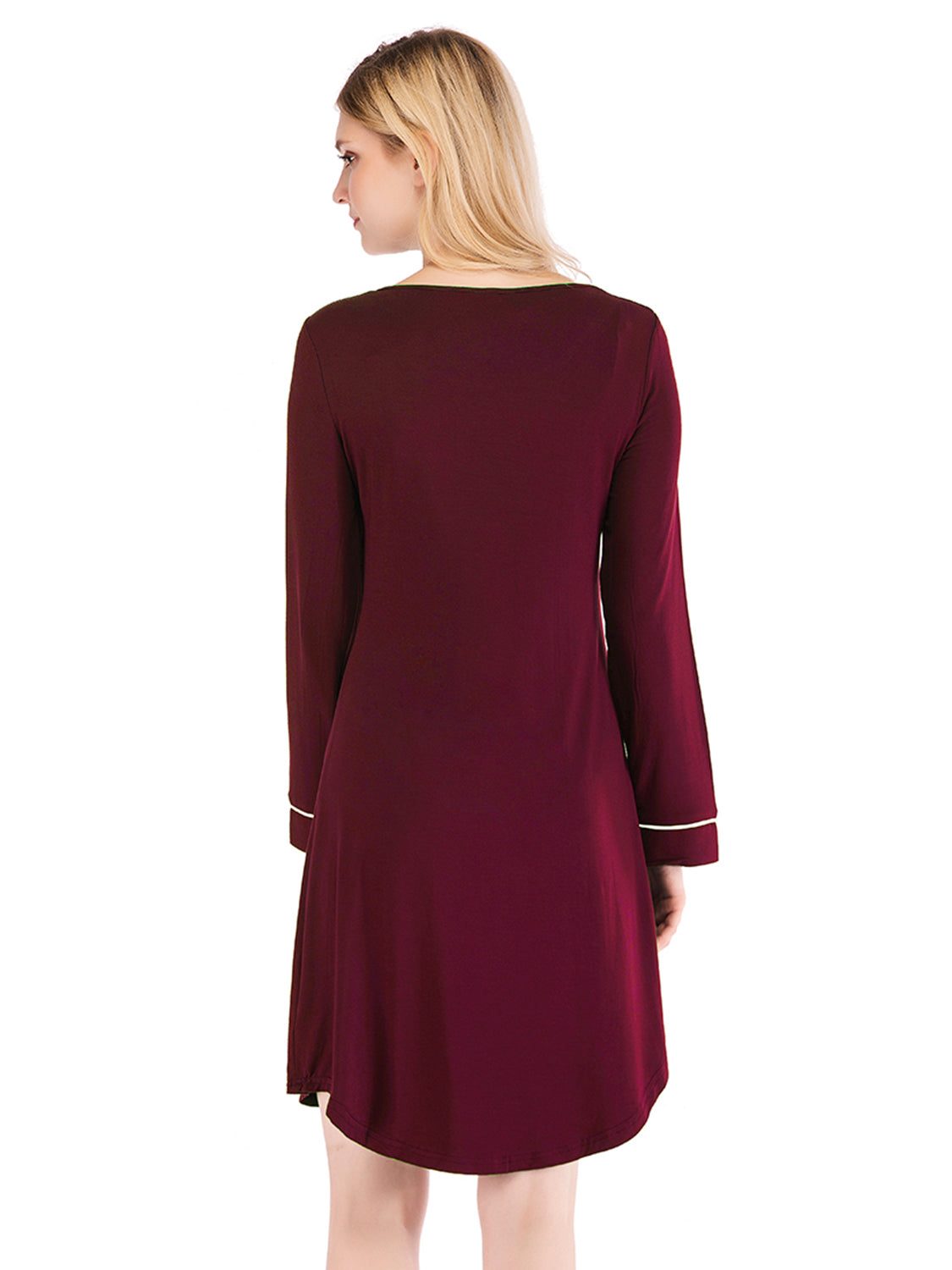 Woman wearing a maroon round neck night dress with long sleeves and a pocket.