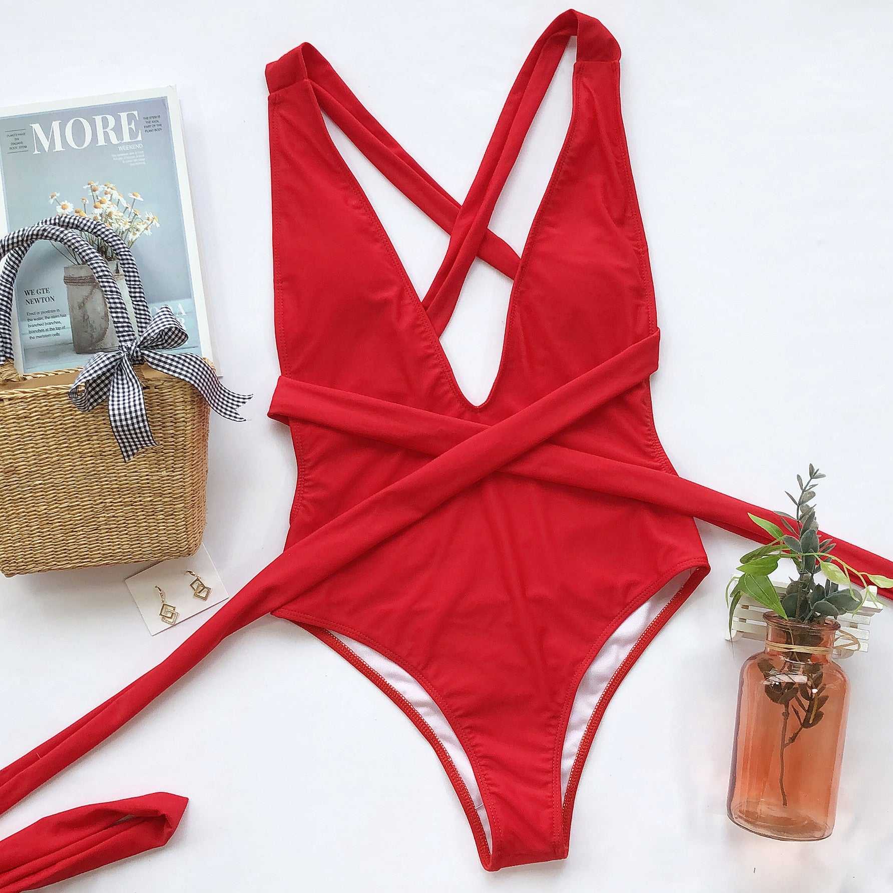 Halter neck deep V tied one-piece swimsuit in solid red with crisscross tie design, features removable padding and highly stretchy fabric.