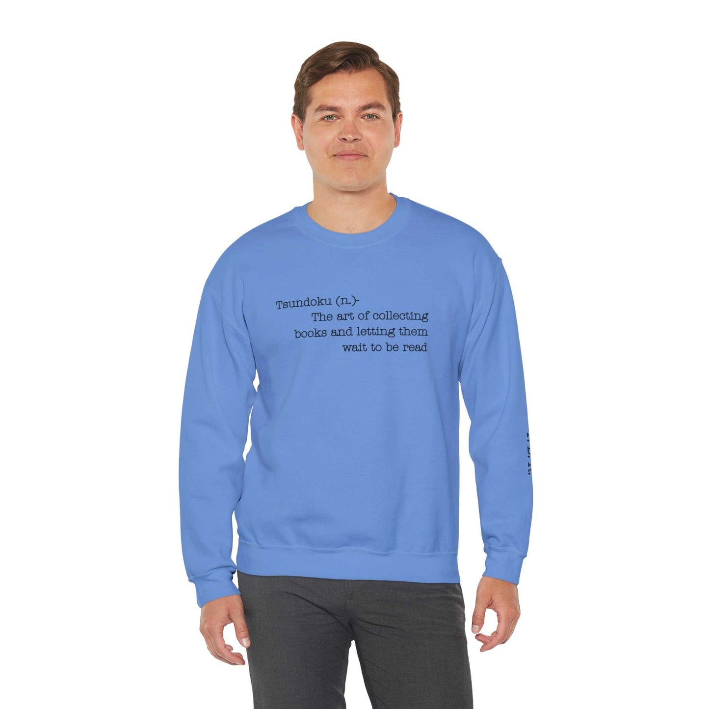 Blue "Tsundoku" crewneck sweatshirt with definition for collectors of unread books, featuring "T.B.R." initials on the sleeve.