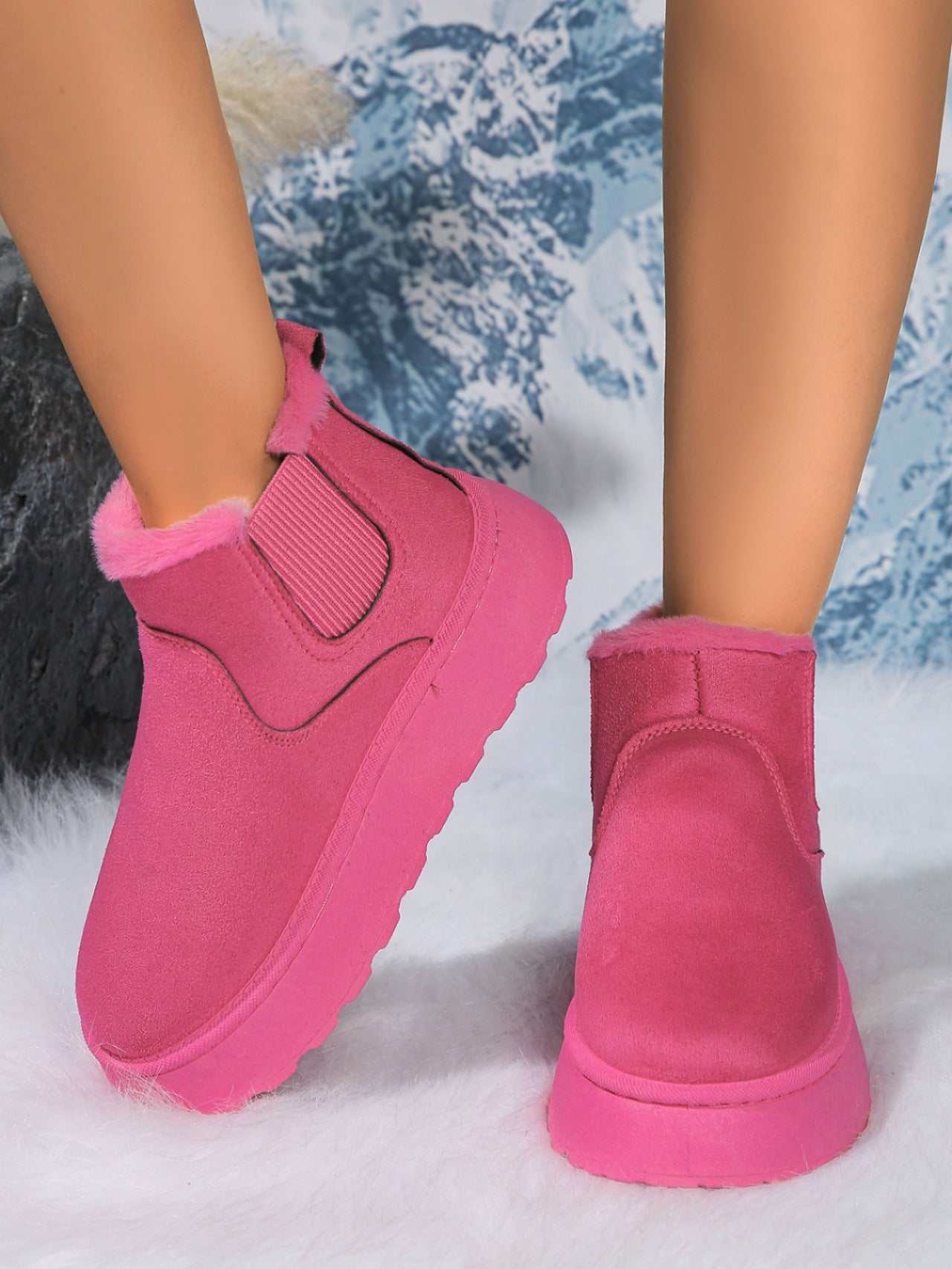 Pink suede round toe platform boots with faux fur trim and rubber soles, displayed on snowy background.