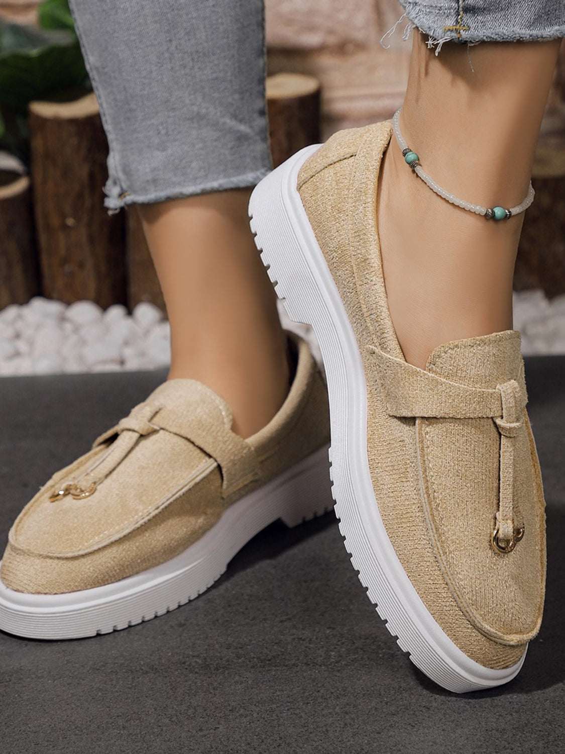 Round toe flat slip-ons made of rubber and polyester, beige color.