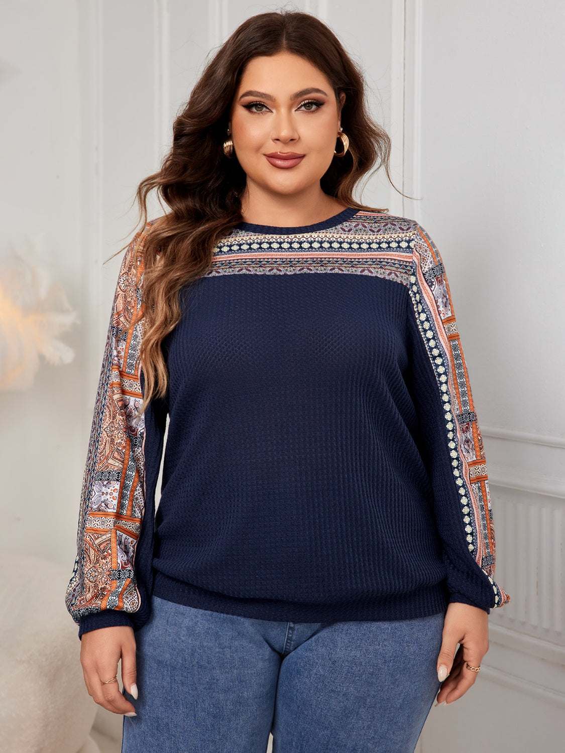 Plus size printed long sleeve sweatshirt in dark blue with decorative patterns, modeled by woman indoors.