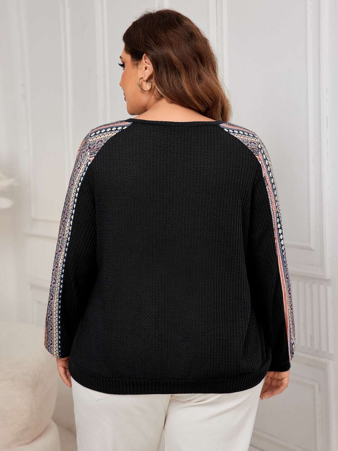 Plus size printed long sleeve sweatshirt, black with patterned sleeves.