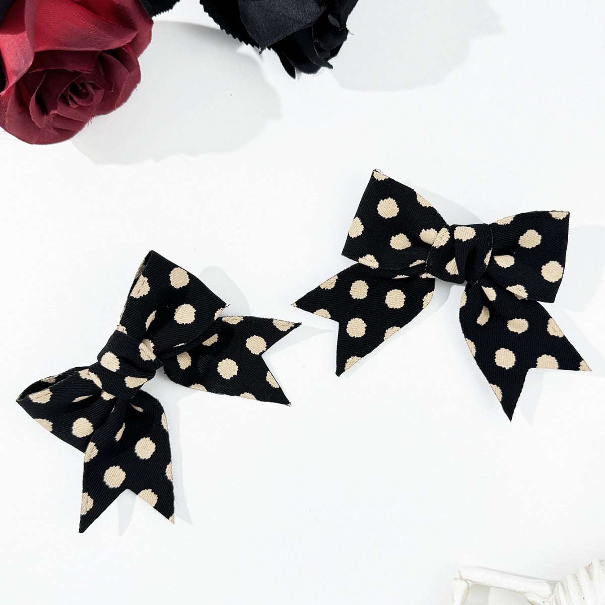 2-piece polka dot bow hair clip set in black polyester, 3.5-inch length.