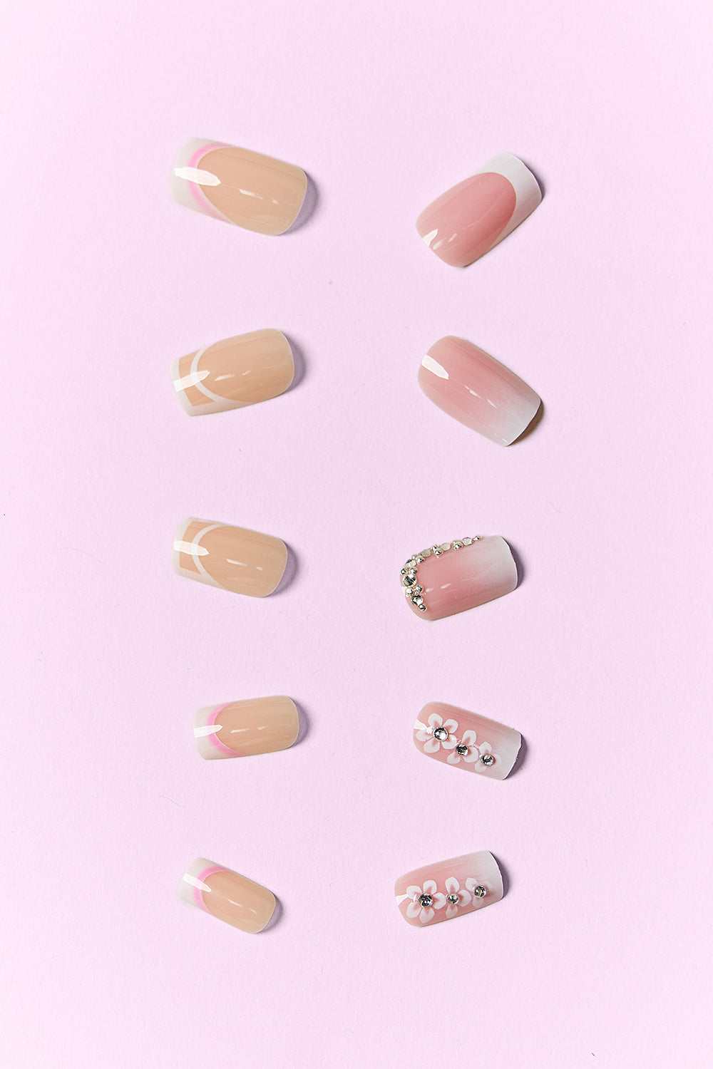 Pink Beauty Press On Nails with chic designs on a pink background.