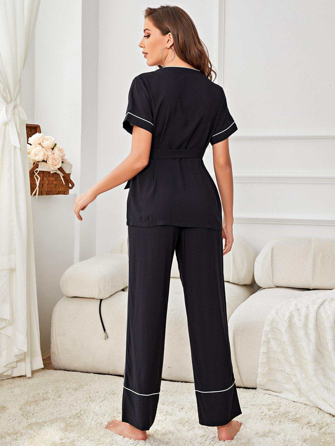 Contrast Piping Belted Top and Pants Pajama Set in black with surplice neckline and long sleeves, minimalist design, studio setting.