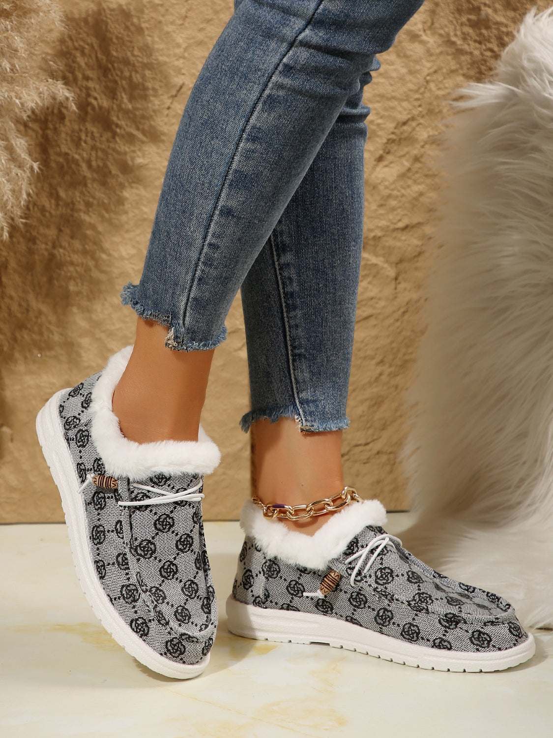 Printed round toe flat slip-ons with faux fur and cotton material, worn with jeans.