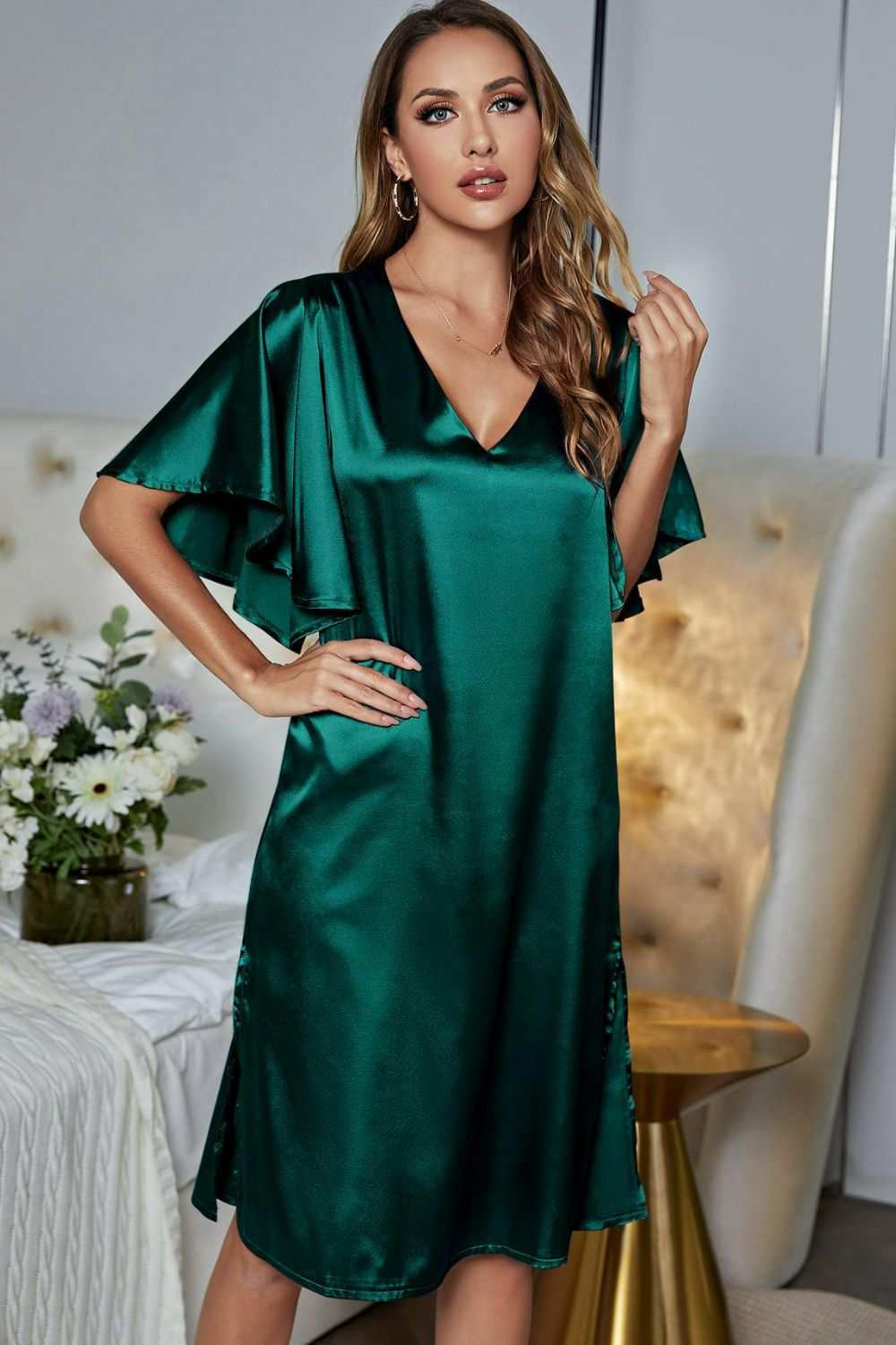 Satin green night dress with flutter sleeves, V-neck, and side slit.