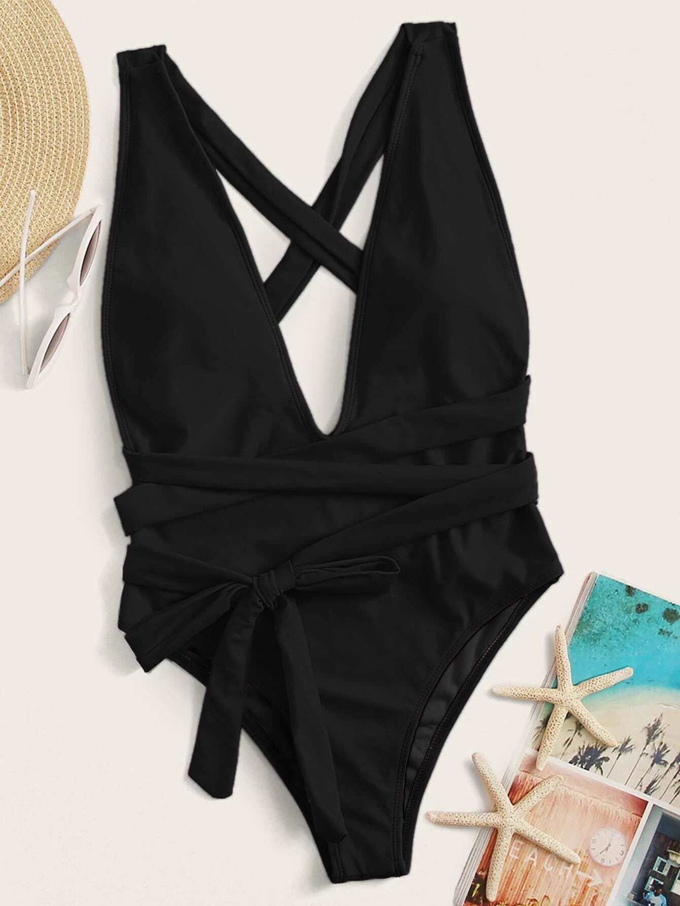 Halter neck deep V tied one-piece swimsuit with solid pattern and crisscross tie detail.