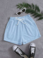 Light blue drawstring pocketed elastic waist shorts with white sneakers and sunglasses.