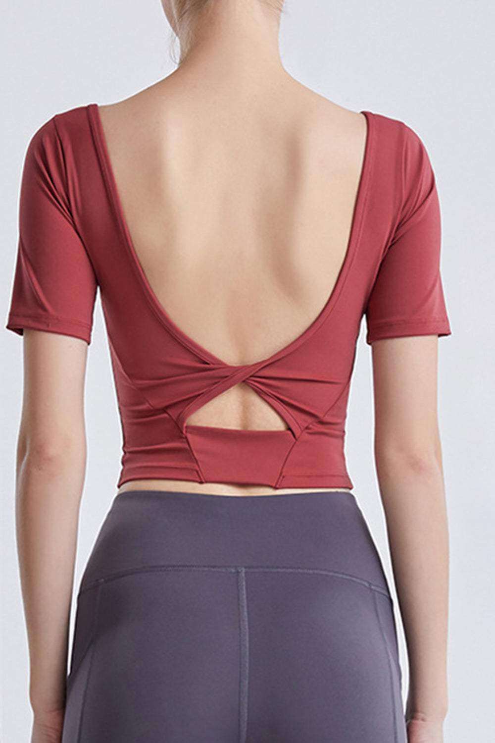 Back view of a cutout backless round neck active T-shirt in red.