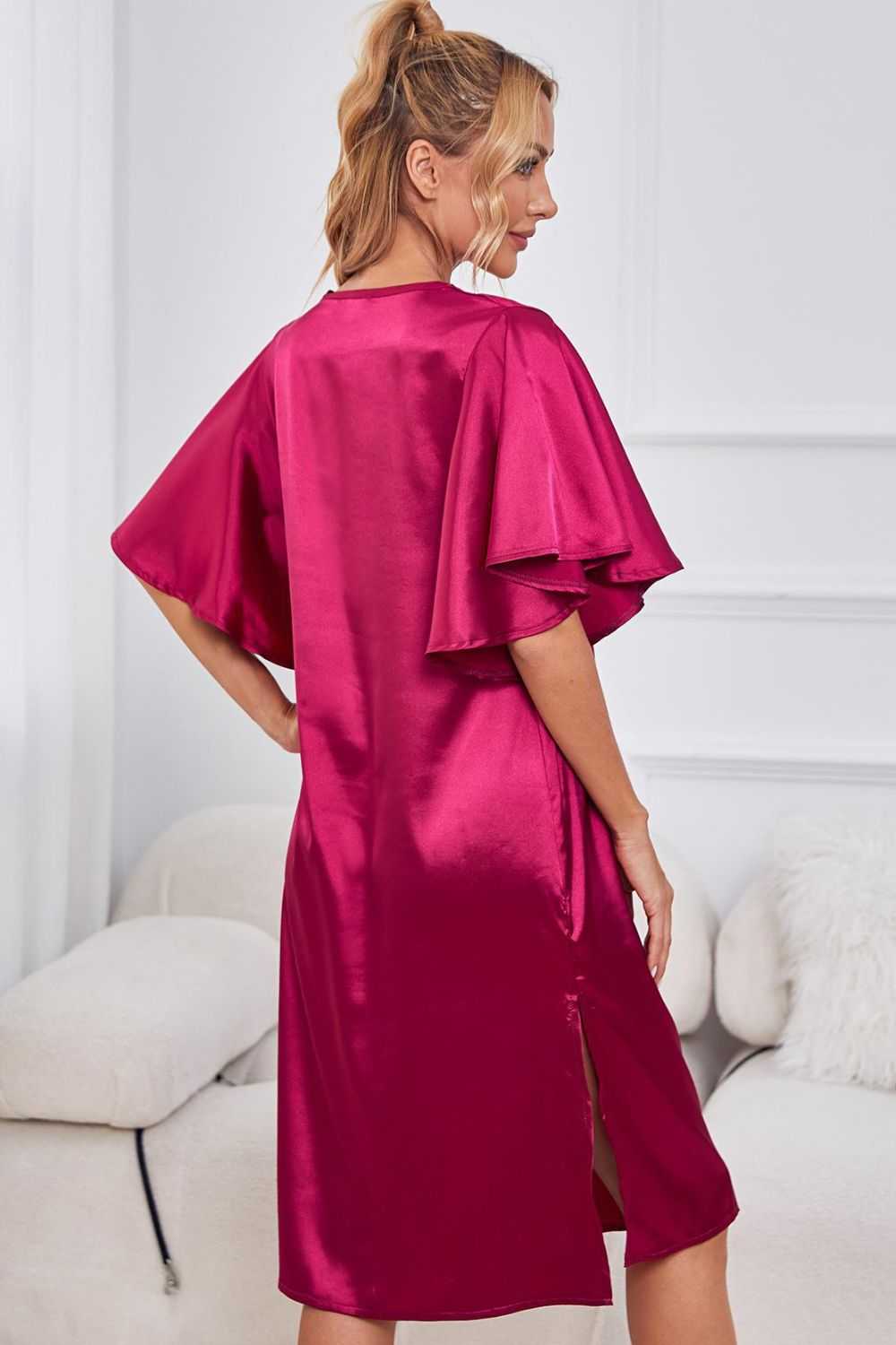 Satin dress with flutter sleeves and side slit in solid color.