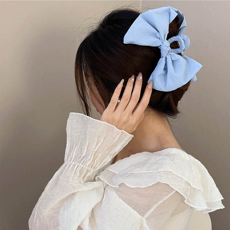 Blue polyester bow hair claw clip in a woman's hair.