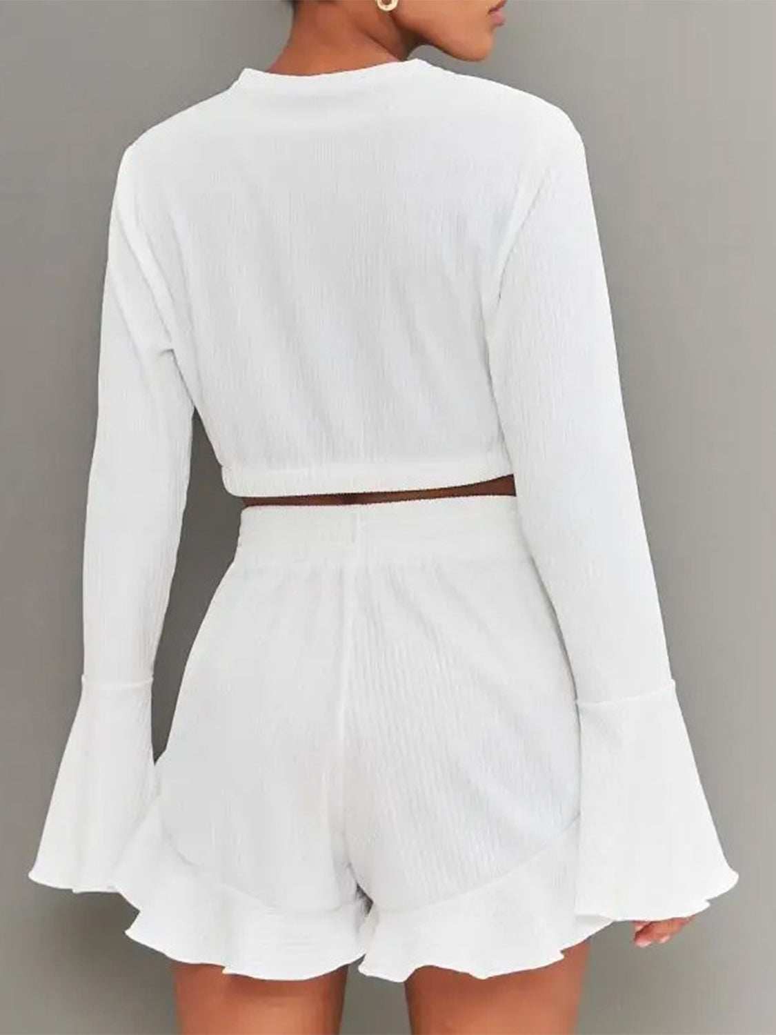 Round neck long sleeve top with peplum features and ruffled shorts set in white.