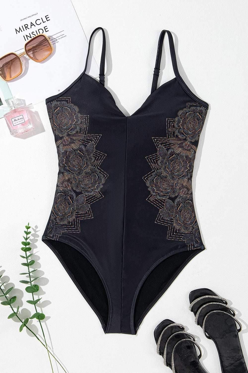 Embroidered V-neck one-piece swimwear with crisscross design and removable chest padding.